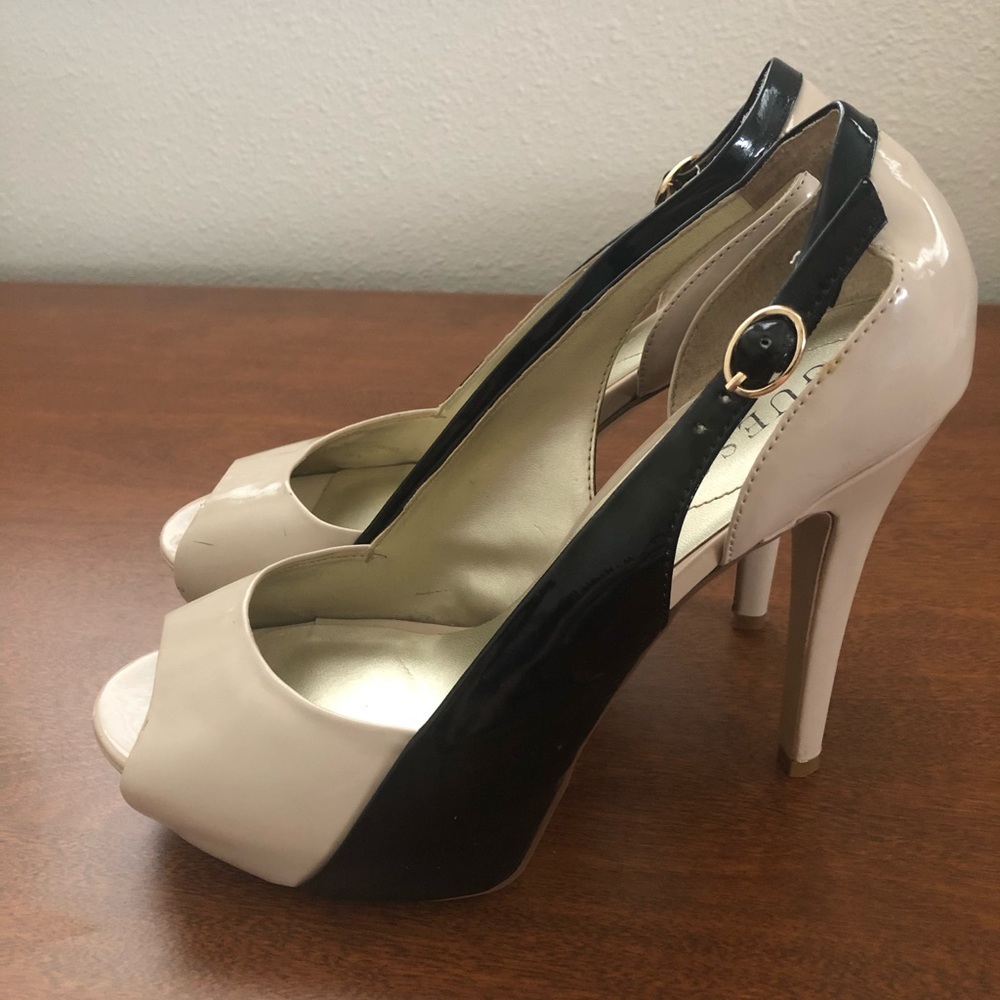 Cream colored heels with a black buckle